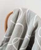 Patterned recycled cotton throw blanket on chair
